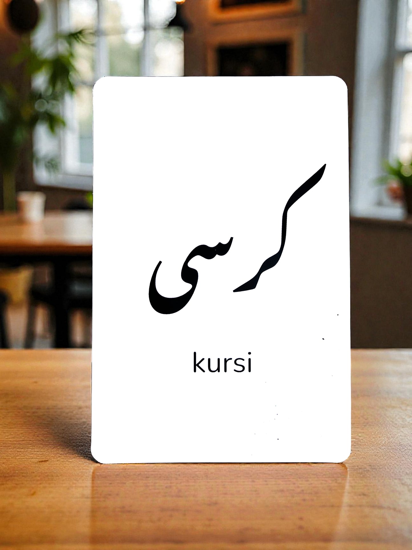 Close-up of Bolo Urdu flash card showing word Kursi with Roman English transliteration